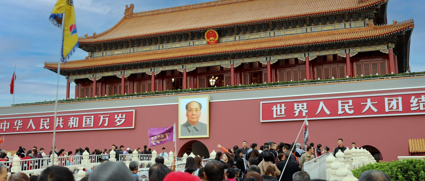 A large crowd gathers at the historic Tiananmen Gate in Beijing, China, showcasing Chinese architecture and culture.