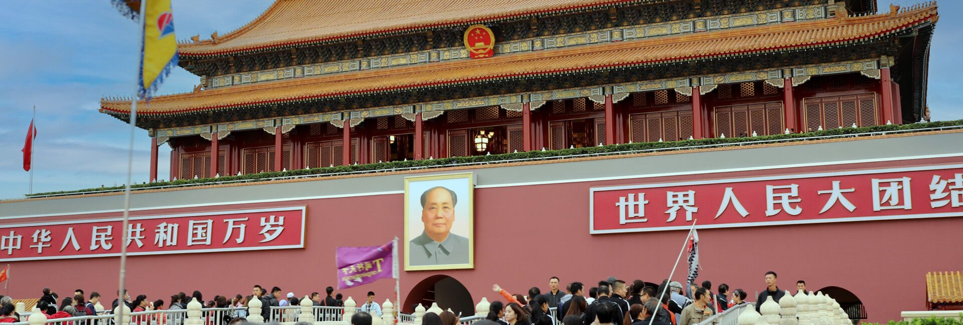 A large crowd gathers at the historic Tiananmen Gate in Beijing, China, showcasing Chinese architecture and culture.