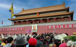 A large crowd gathers at the historic Tiananmen Gate in Beijing, China, showcasing Chinese architecture and culture.