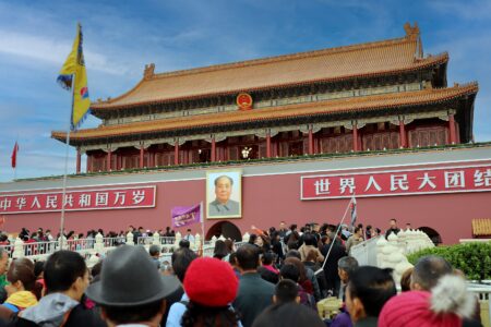 A large crowd gathers at the historic Tiananmen Gate in Beijing, China, showcasing Chinese architecture and culture.
